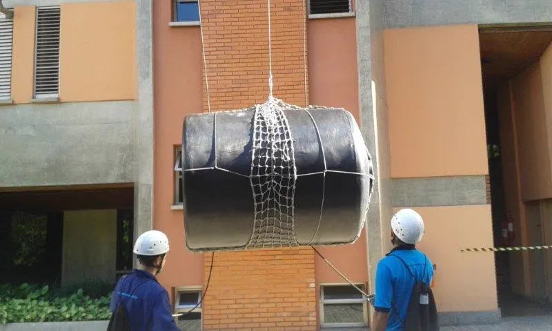 Equipe da JLT içando caixa d'água com rede de proteção